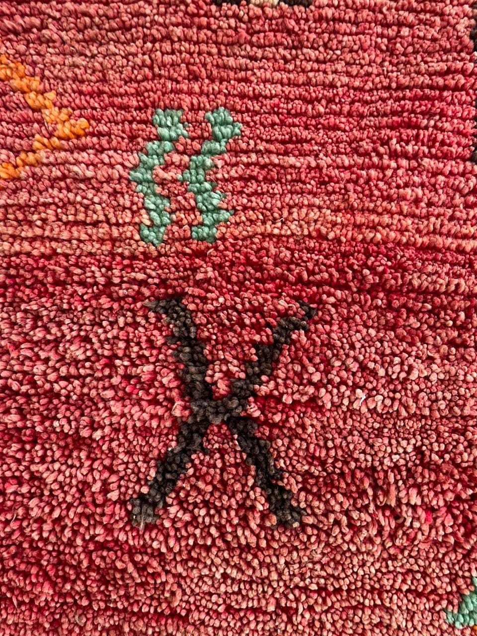Detail view of abstract designs in red, black, and orange on the Moroccan rug.