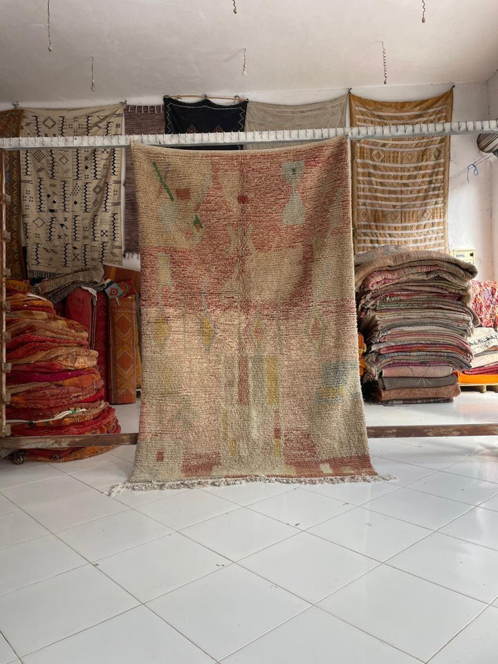 Detail view of a colorful vintage Moroccan rug featuring a woven texture in beige, red, and yellow.