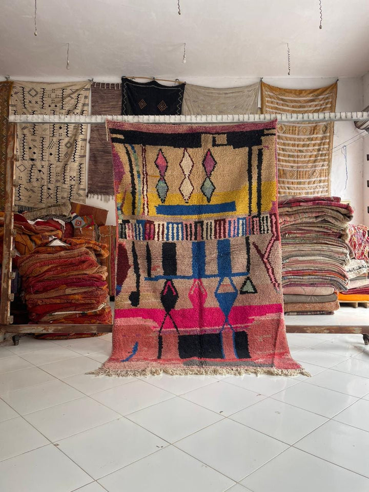 Lifestyle shot of a colorful Moroccan rug with geometric patterns in a natural setting.