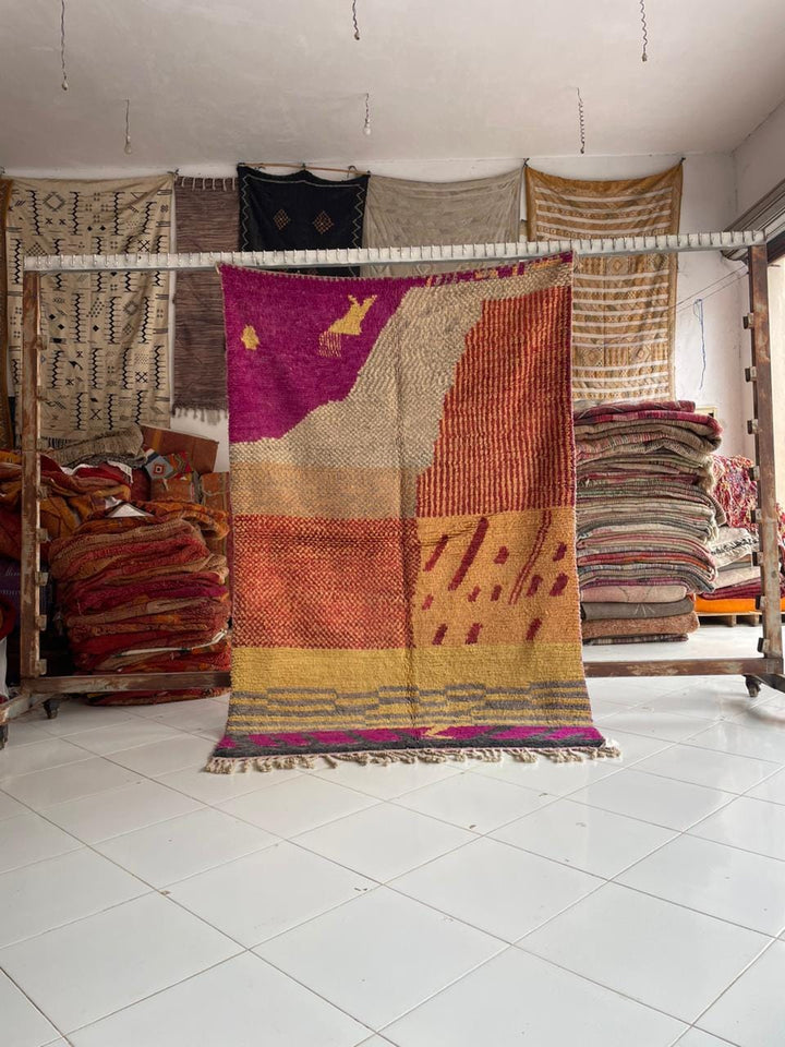 Lifestyle shot of a colorful Moroccan rug featuring vintage design and fringe edges.