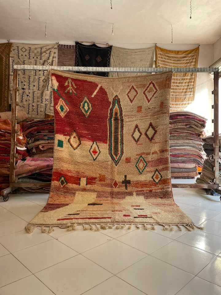Lifestyle shot of a colorful tribal Boujaad Moroccan rug featuring red, beige, and green patterns.