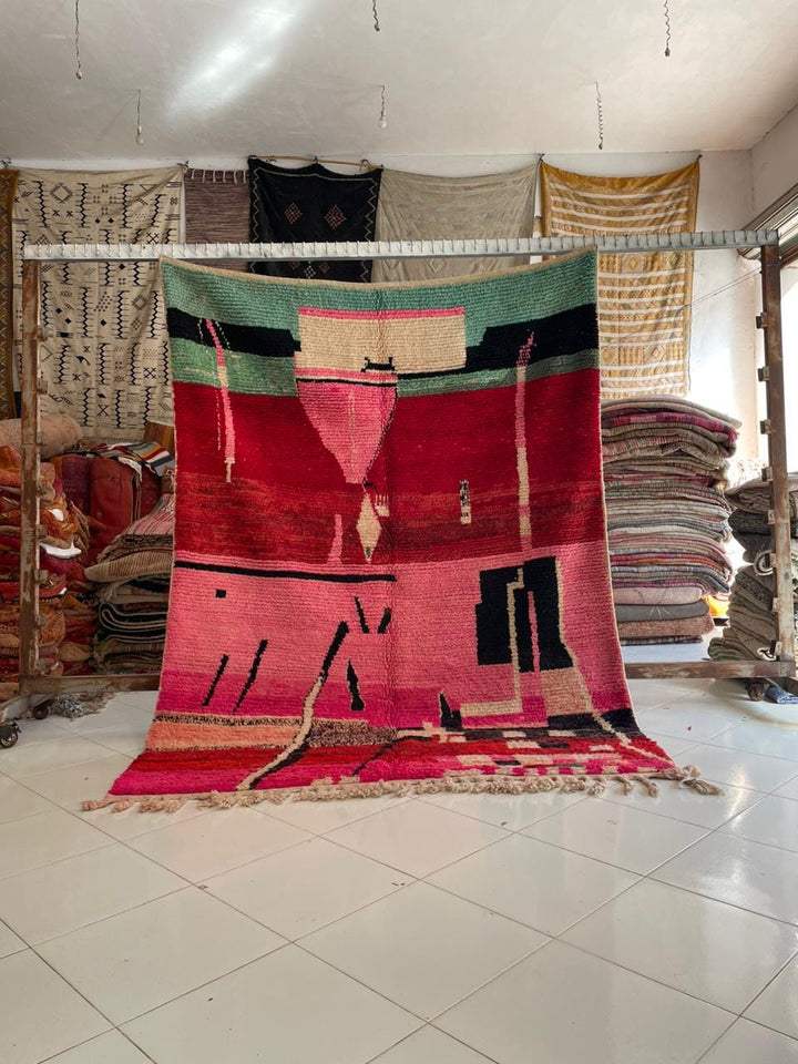 Lifestyle shot of a colorful Moroccan rug with geometric patterns and fringe edges.