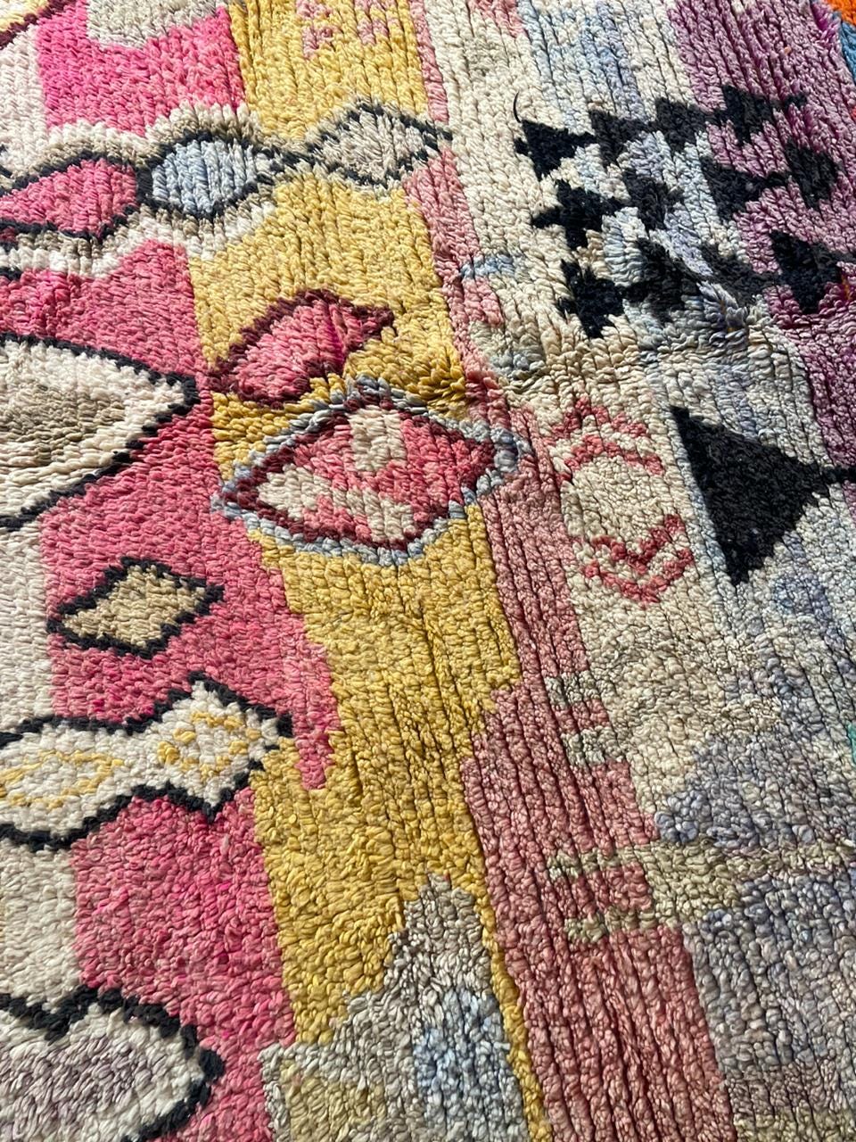 Detail close-up of a rug pattern highlighting geometric shapes on a textured surface.