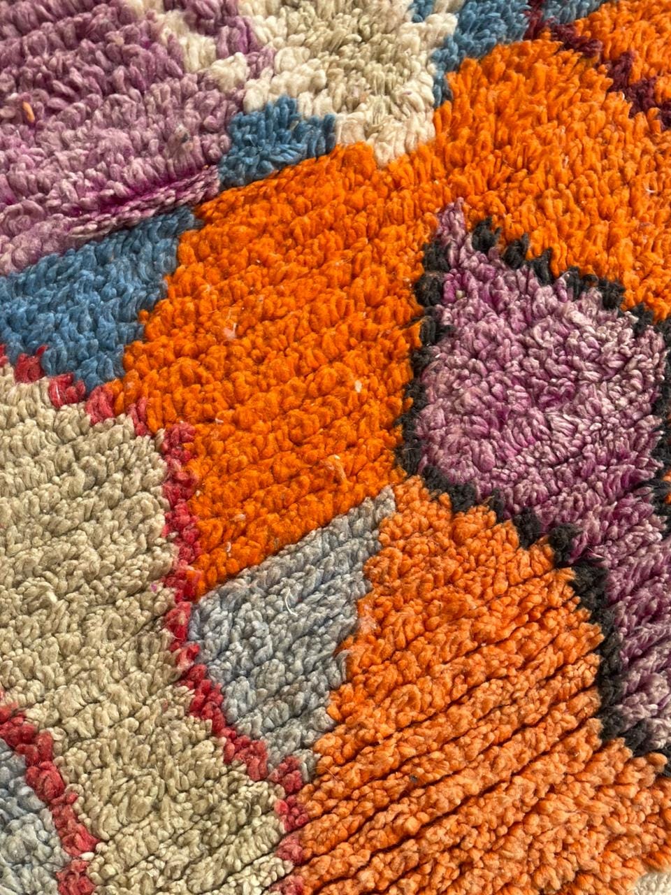 Front view of a colorful rug displaying varied patterns and fringe edges against a white background.