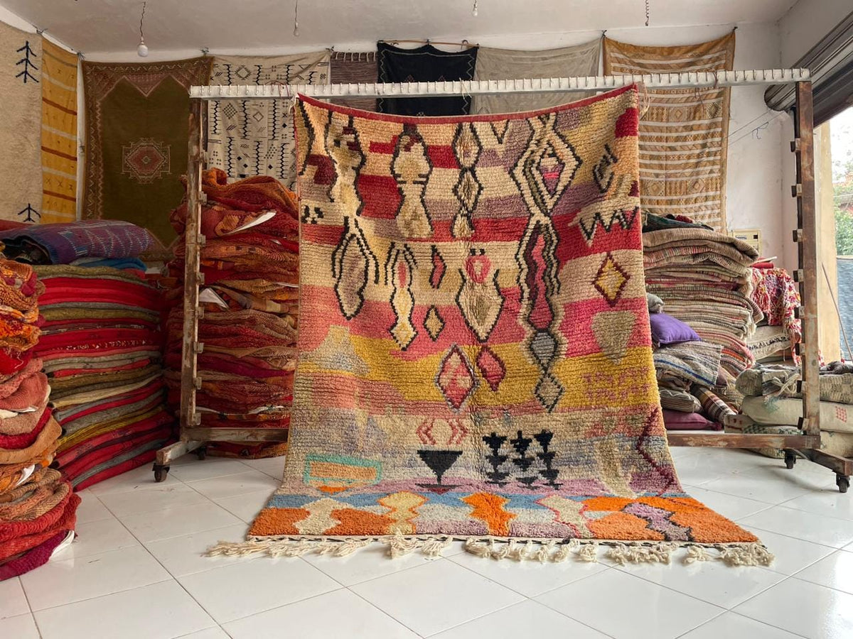 Lifestyle shot of a display of colorful rugs with various patterns and decorative items.