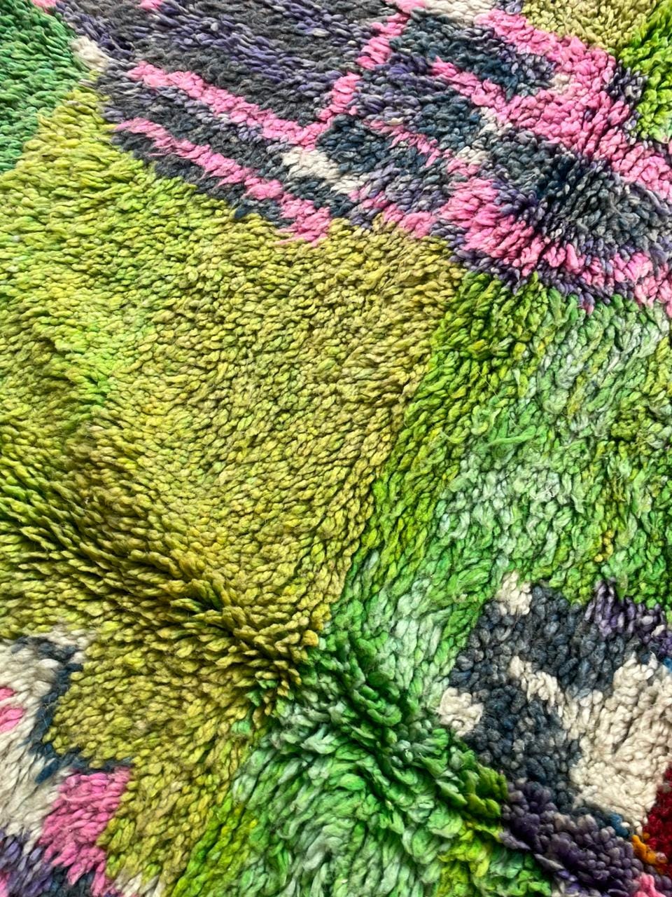 Close-up detail of a colorful Moroccan rug with a textured surface and vibrant colors.