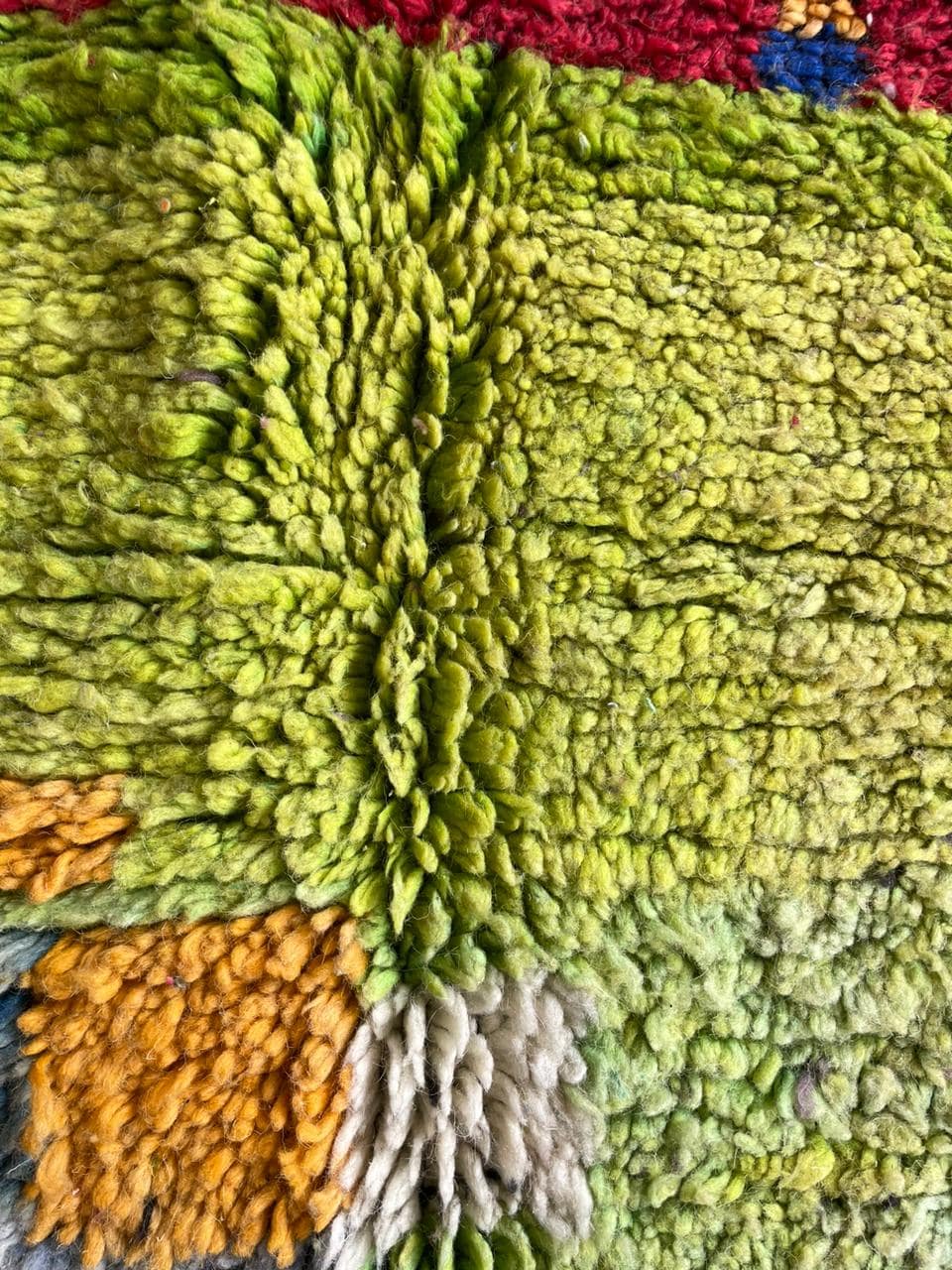 Close-up detail of a colorful Moroccan rug showcasing a textured surface and abstract patterns.
