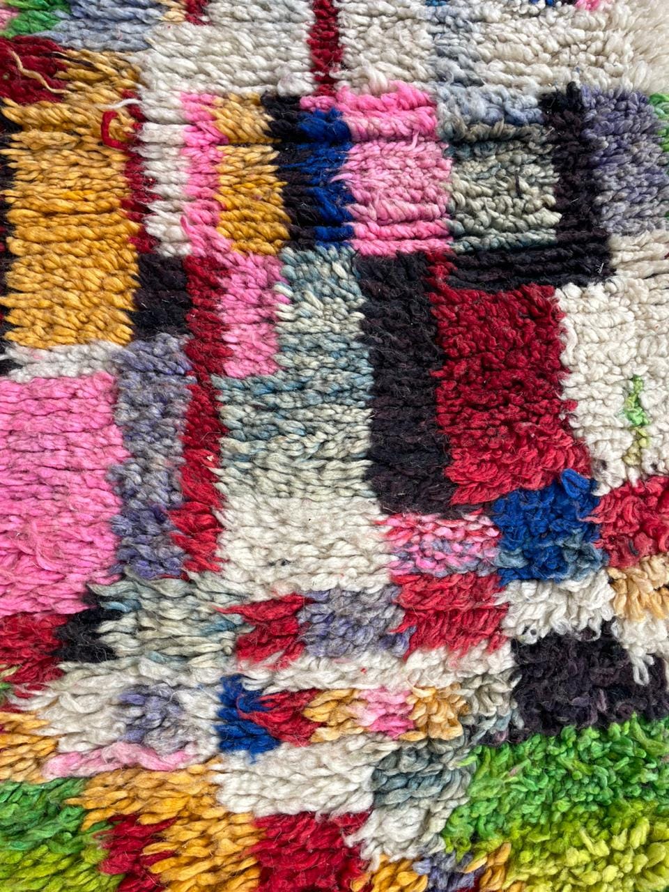 Close-up detail of a colorful Moroccan rug showcasing thick pile and multicolored patches.