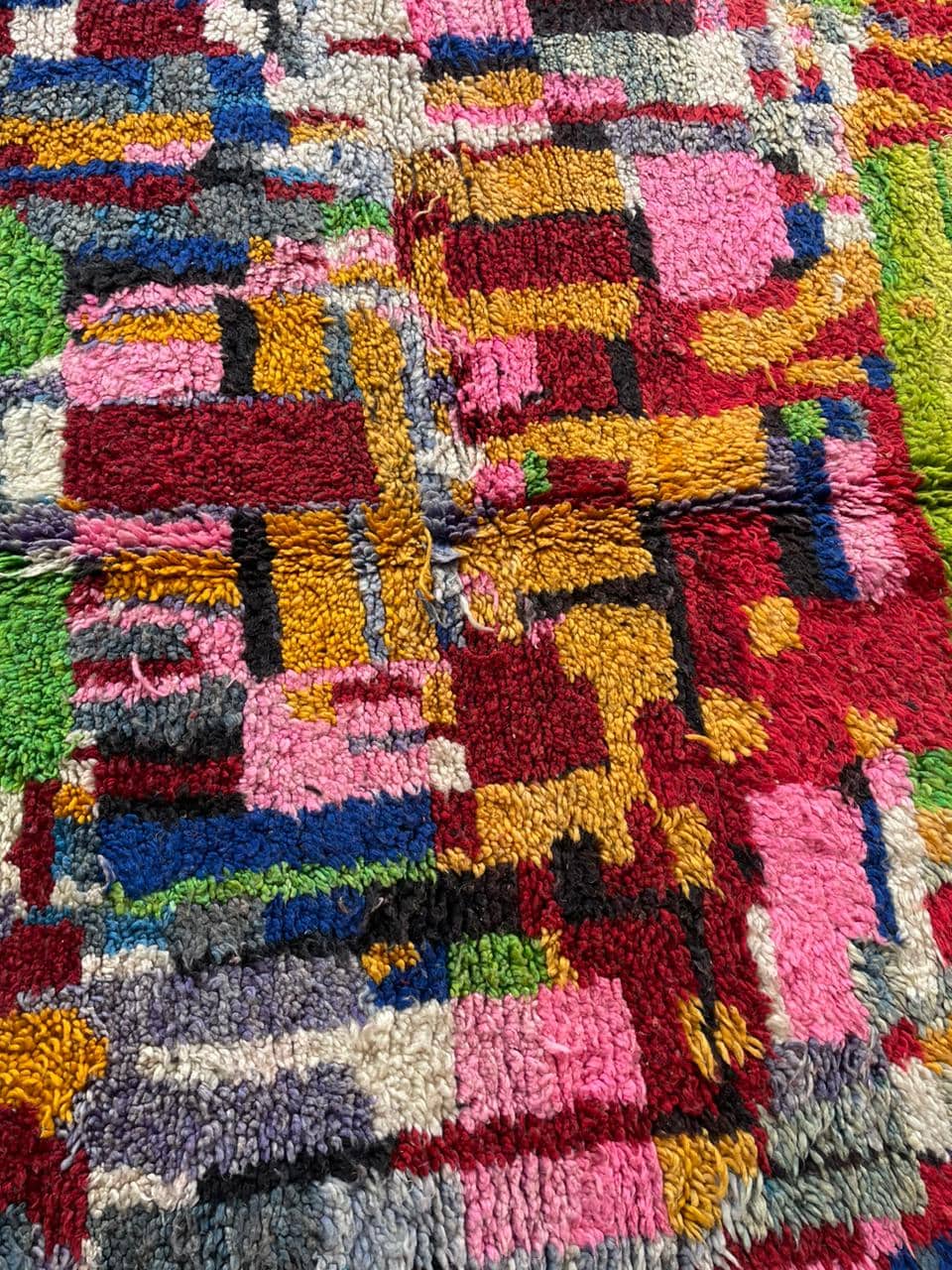Close-up detail of a colorful Moroccan rug with a textured surface and varied patterns.