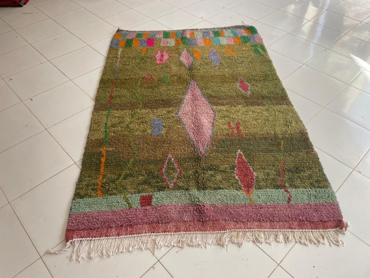 Front view of a green Moroccan rug showcasing tribal patterns on a white background.