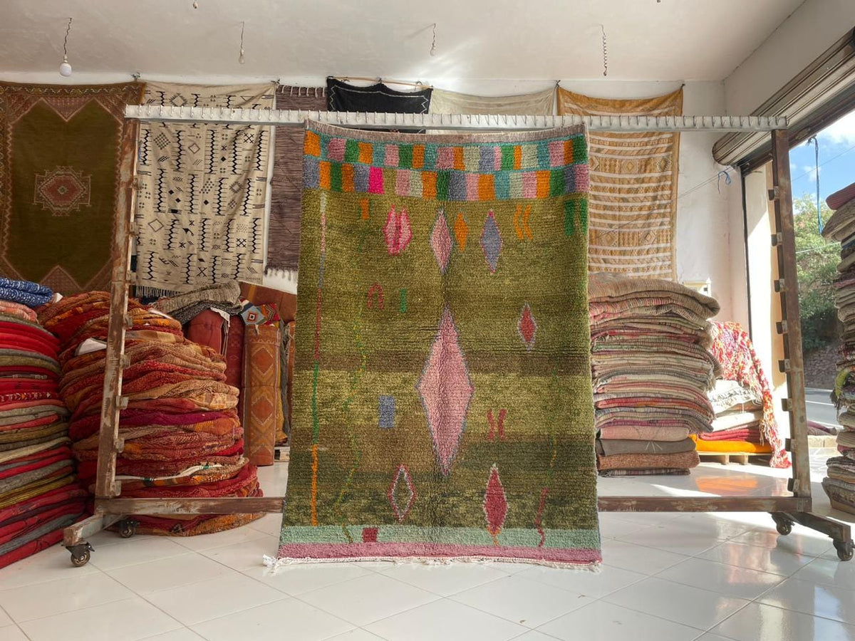 Lifestyle shot of a green tribal rug with vintage design and tribal patterns.