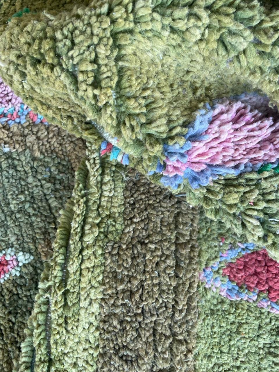 Detail close-up of a colorful rug pattern with an abstract design and textured surface.
