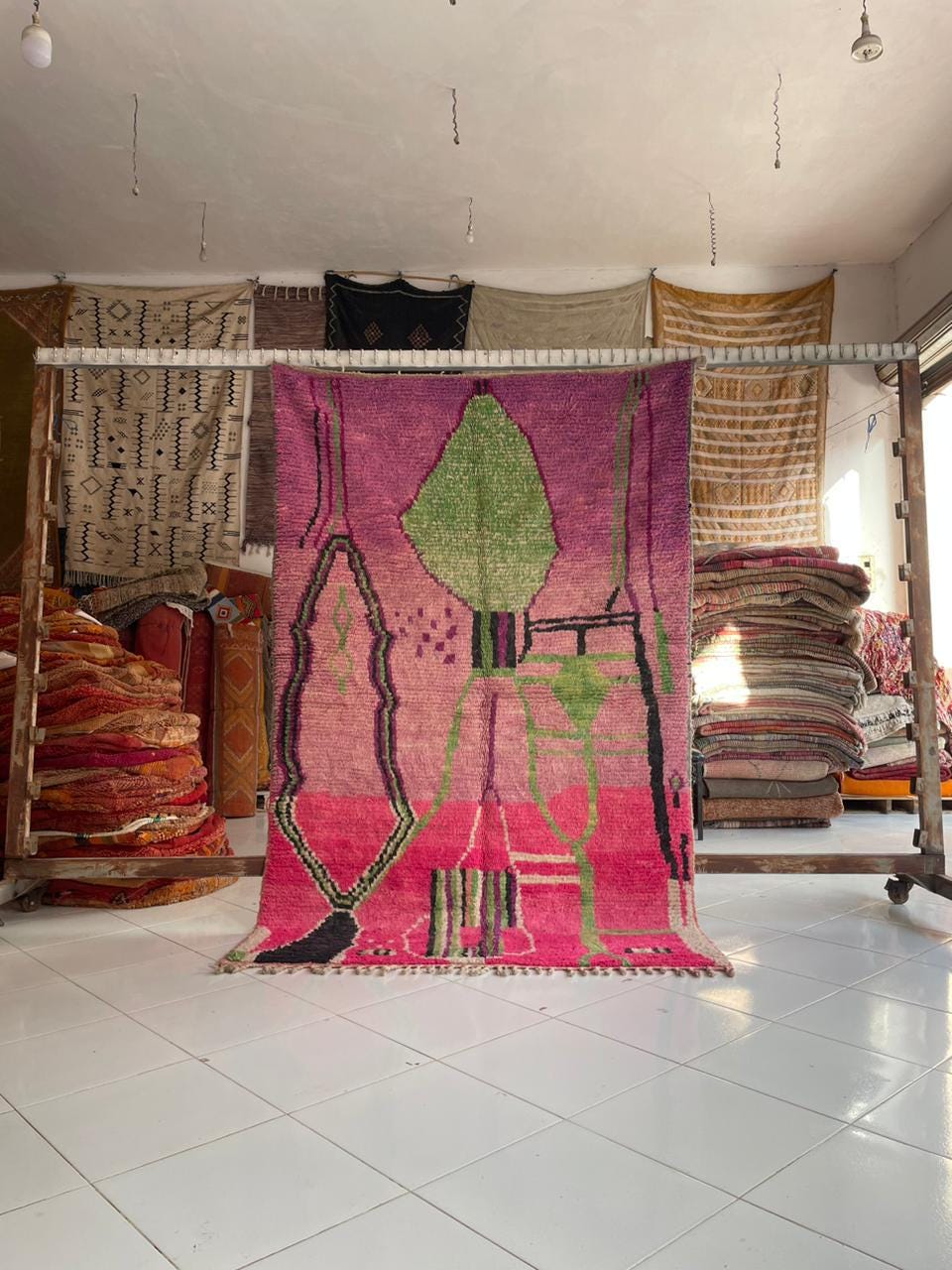Lifestyle shot of a pink Moroccan rug featuring geometric patterns in a natural setting.