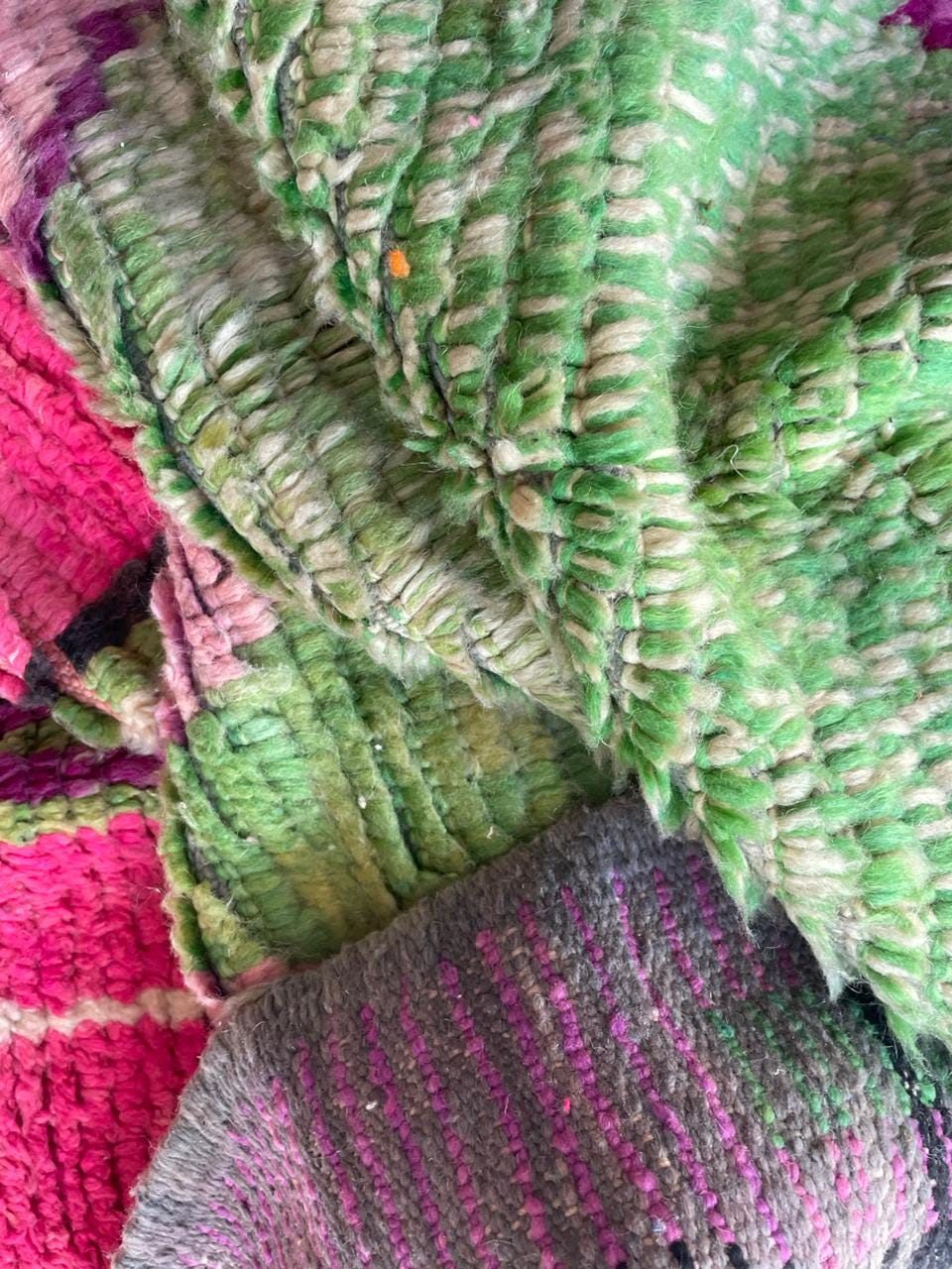 Detail view of a pink Moroccan rug showcasing colorful fibers and a soft texture.