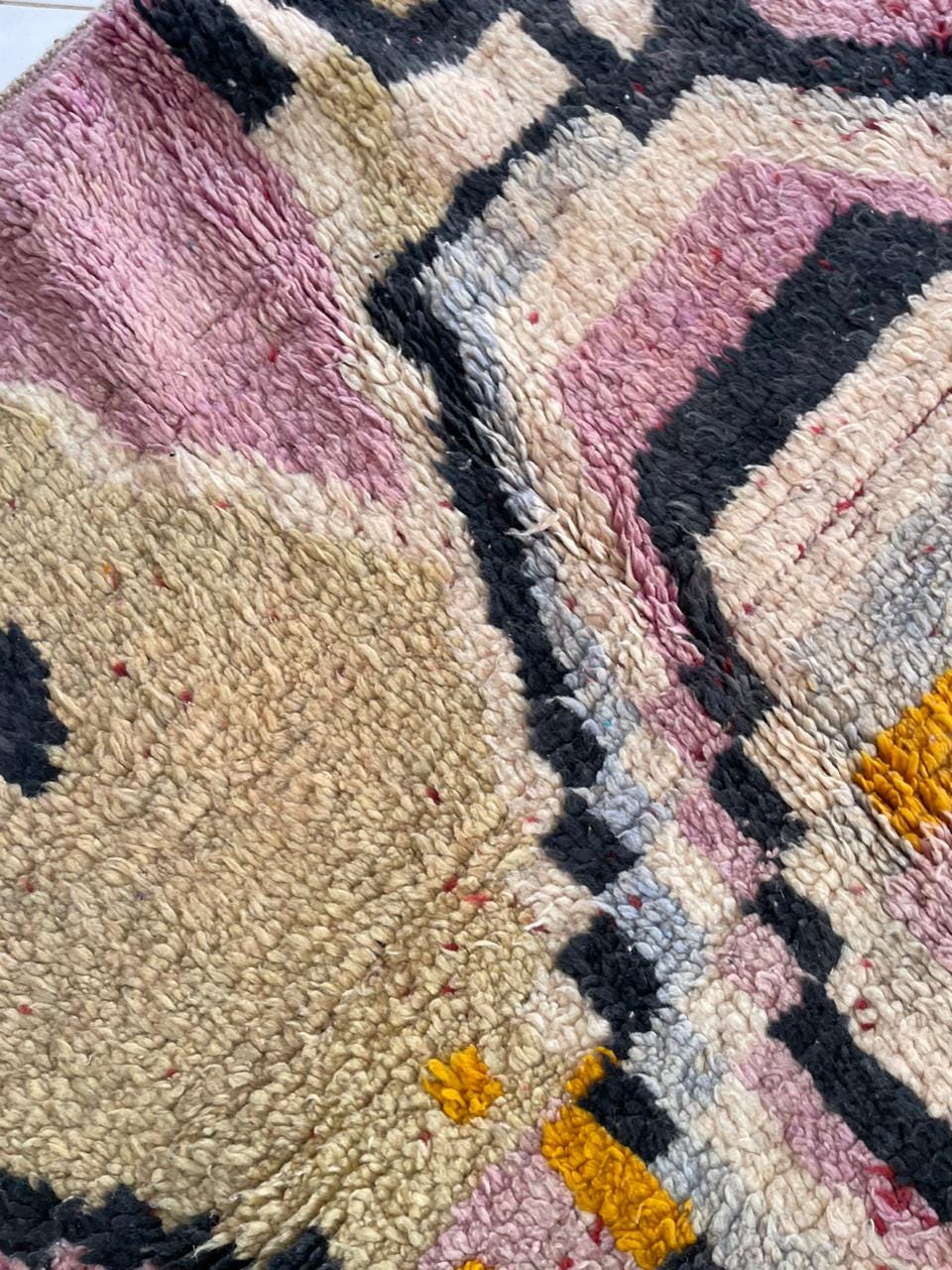 Detail shot of the colorful Moroccan rug with layered patterns and a fluffy texture.