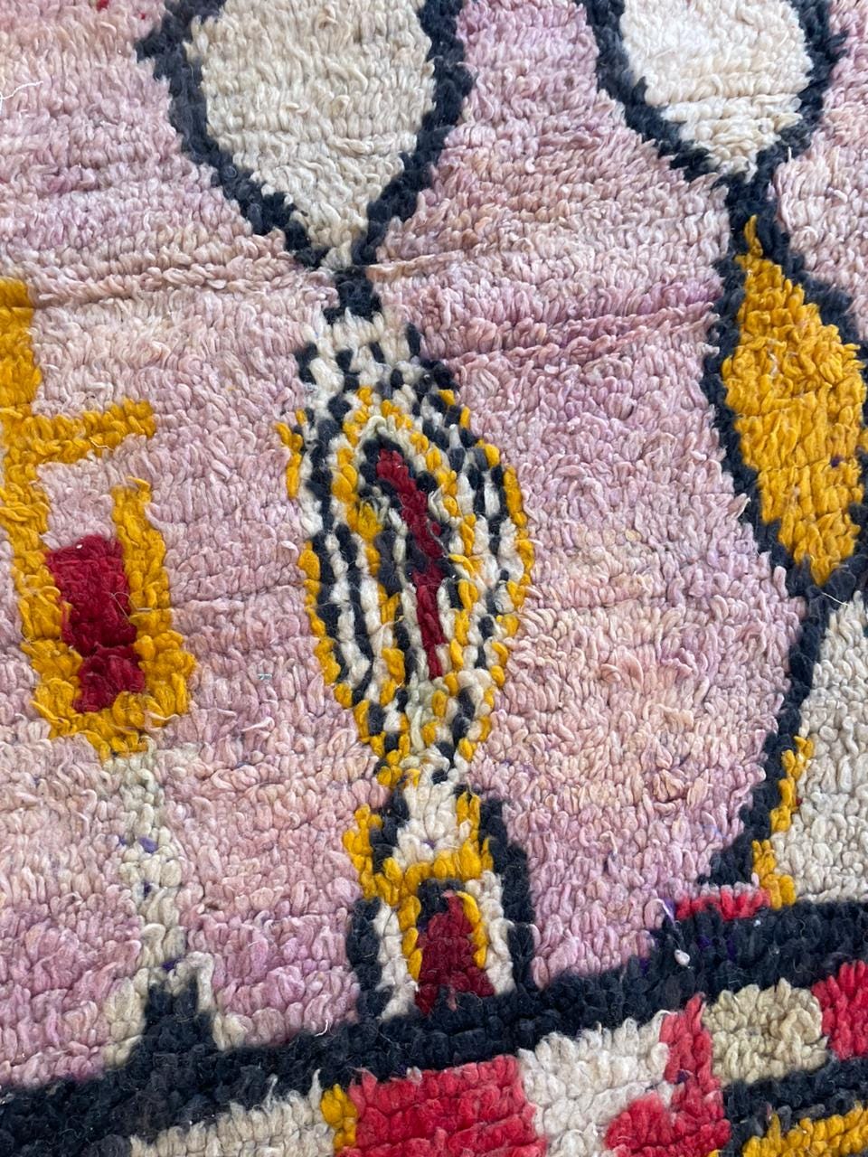 Detail shot of the pink vintage Moroccan rug with close-up patterns and colorful details.