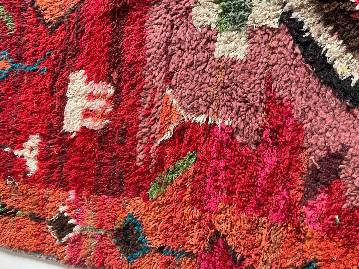 Close-up detail of colorful designs and thick pile on the red and pink Boujaad Moroccan rug.