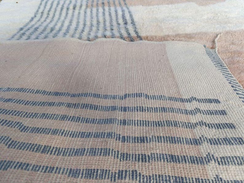 Close-up detail of a Moroccan rug showcasing a striped design in beige and brown.