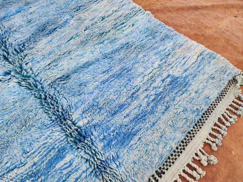 Detail view of the blue rug's fringe edge showcasing its soft texture.