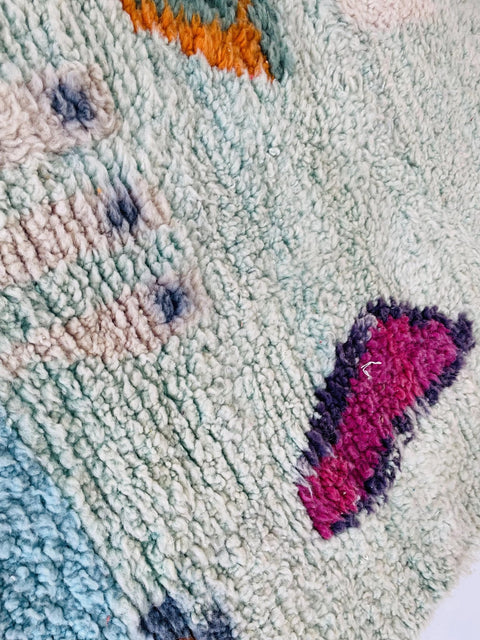 Detail shot of the abstract design on the blue and red Moroccan rug.