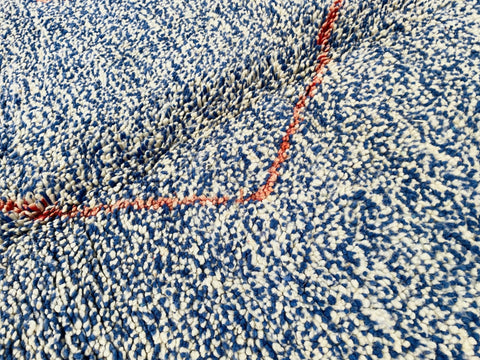 Close-up detail of the abstract design on the blue and red Beni Ourain Moroccan rug.