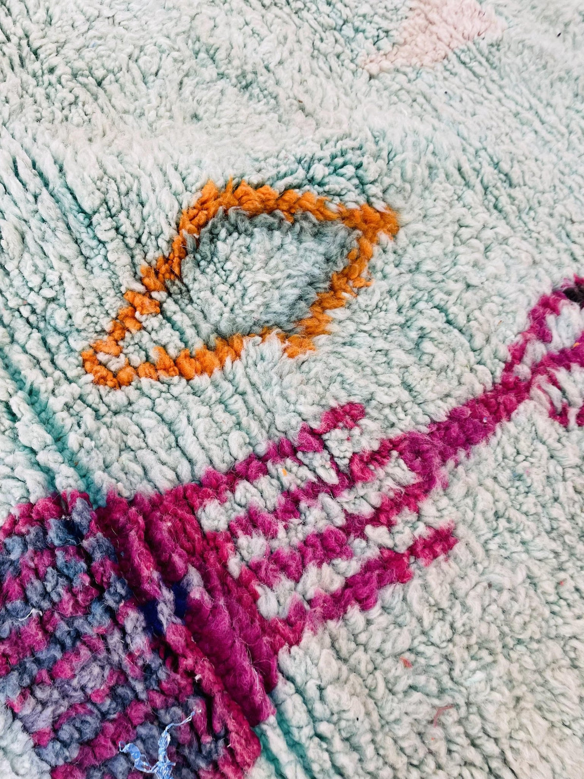 Close-up of the abstract pattern on the blue and red Beni Ourain Moroccan rug.