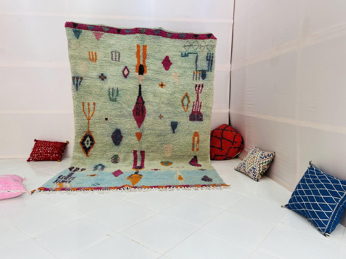 Lifestyle shot of the blue and red abstract Beni Ourain Moroccan rug on a white background.