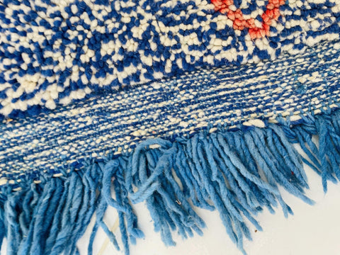 Detail shot highlighting the fringe edges of the blue and red Beni Ourain Moroccan rug.