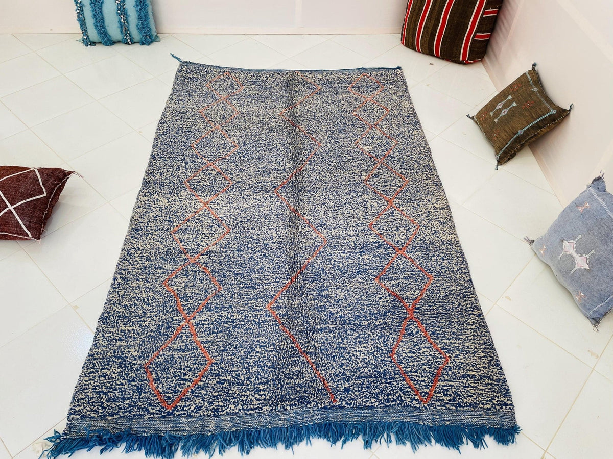 Top view of the blue and red Beni Ourain Moroccan rug showcasing its abstract pattern.