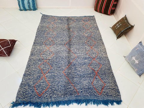 Top view of the blue and red Beni Ourain Moroccan rug showcasing its abstract pattern.