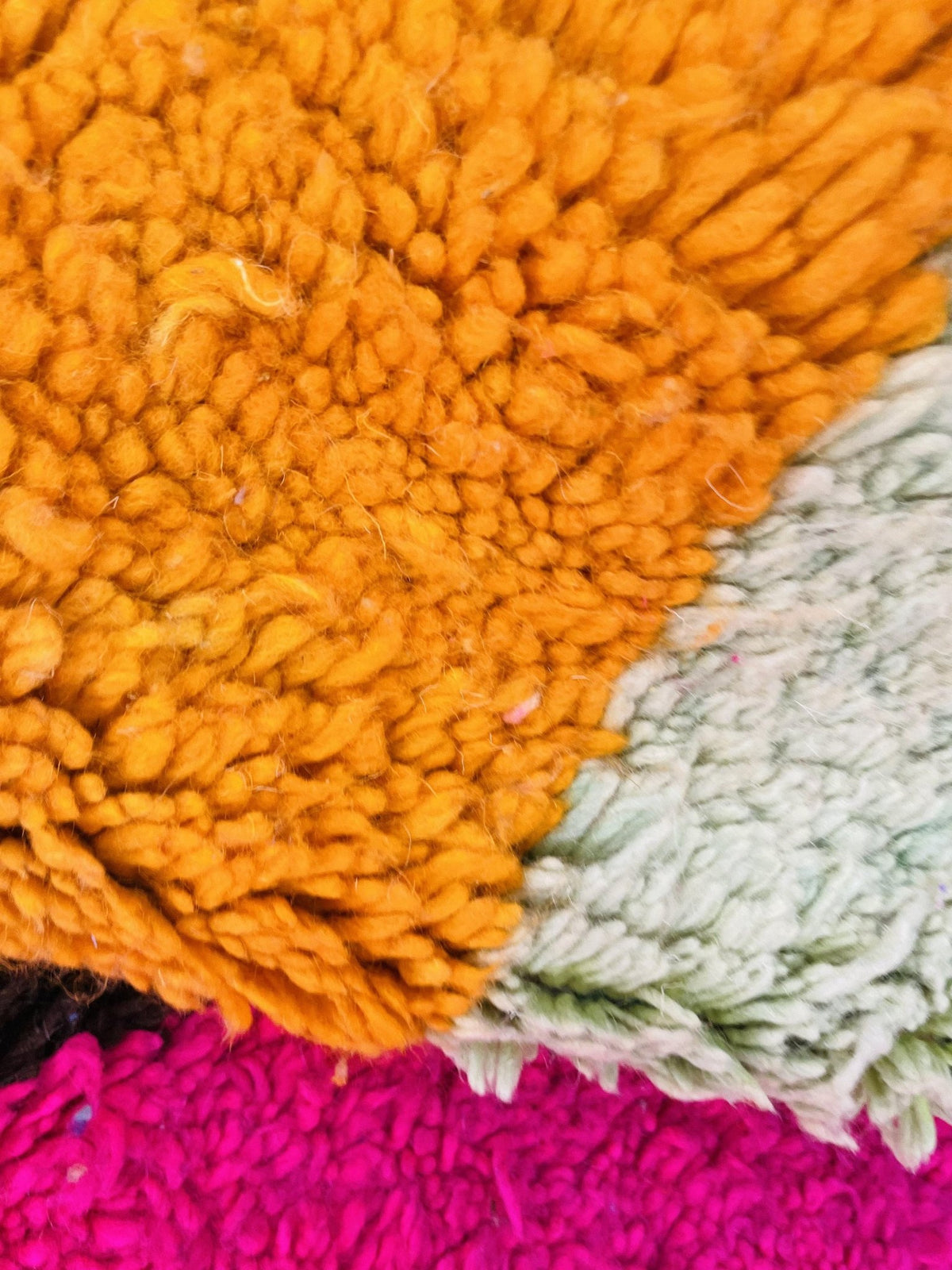 Lifestyle angle showcasing a colorful orange and blue abstract Moroccan rug on a white backdrop.