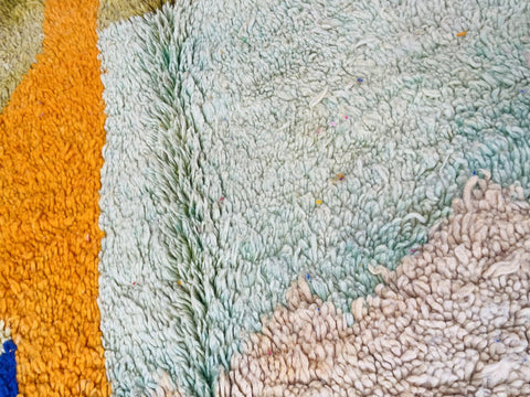 Detail shot of a colorful orange and blue Moroccan rug showcasing its vibrant colors and texture.