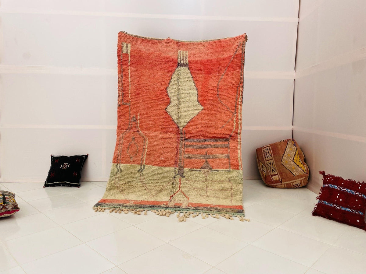 Lifestyle shot of the orange geometric Beni Ourain Moroccan rug on a white background.
