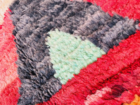 Close-up detail of a colorful Moroccan rug with a textured pattern and geometric design.