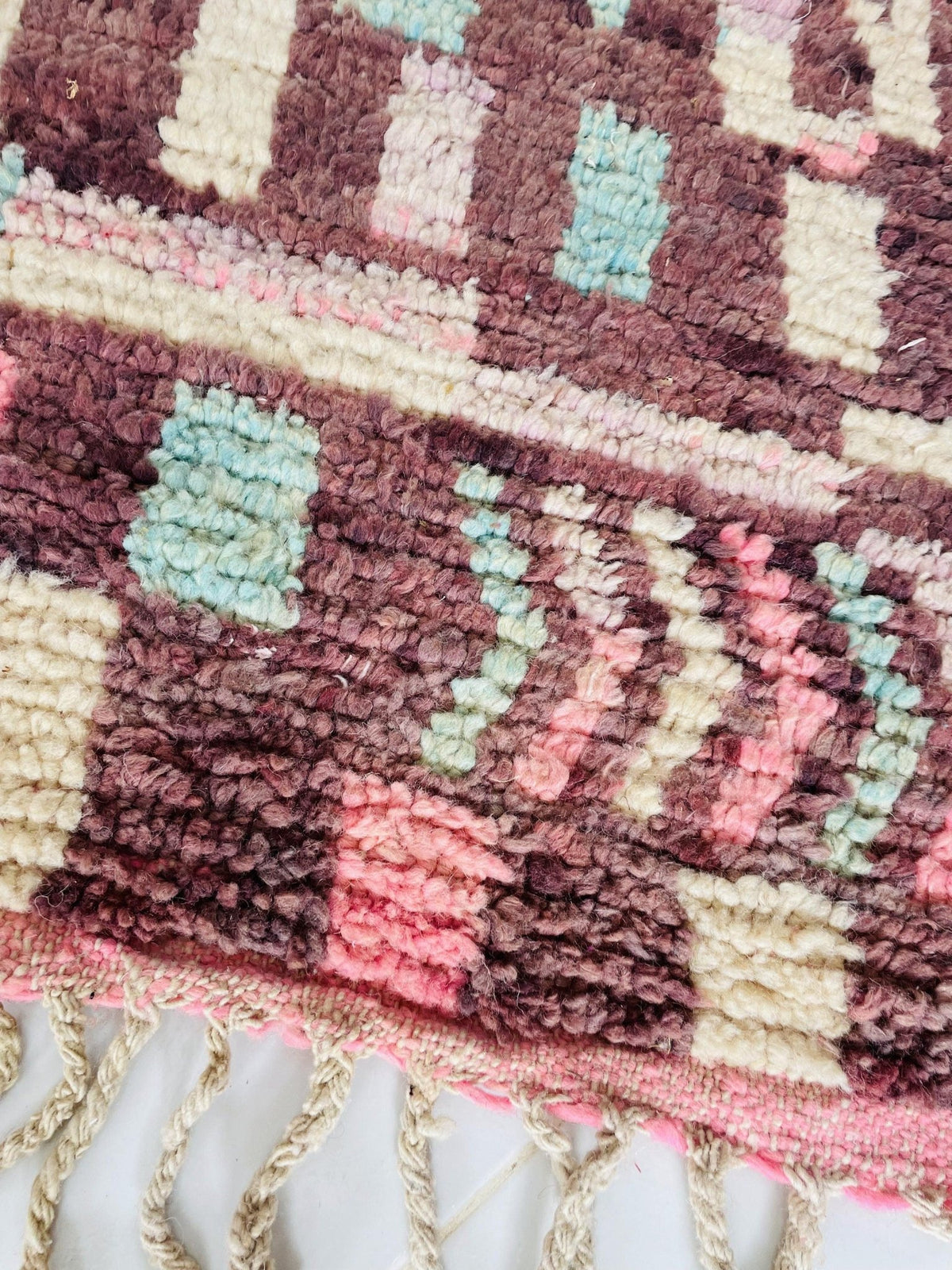 Close-up detail of a pink and blue Moroccan rug showcasing its intricate design and texture.