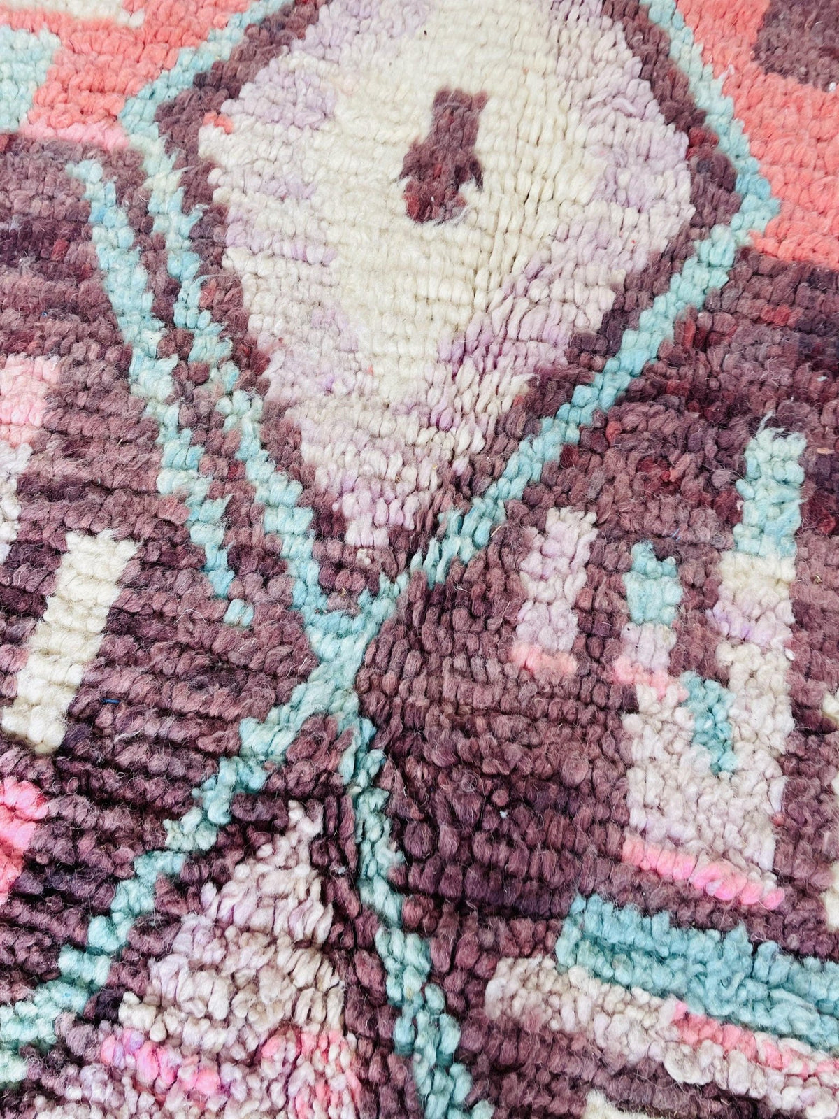 Close-up detail of a cream and blue Moroccan rug highlighting geometric patterns and texture.