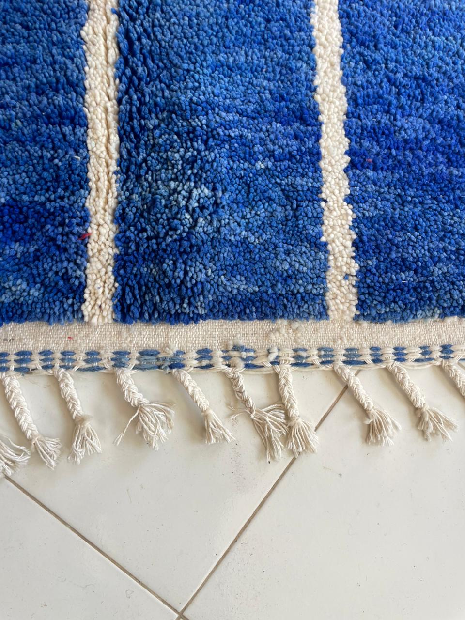 Detail view of a blue Beni Ourain Moroccan rug showcasing tufted texture and fringe detail.