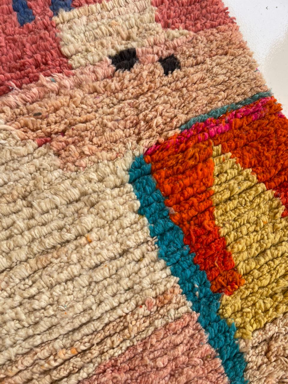 Detail close-up of a colorful Berber rug showcasing a textured weave and geometric patterns.