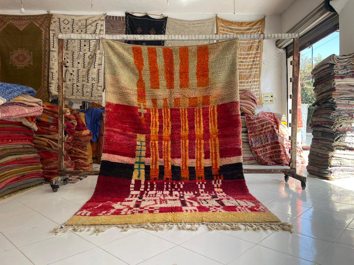Lifestyle shot of a colorful Berber rug featuring geometric patterns and fringe edges.