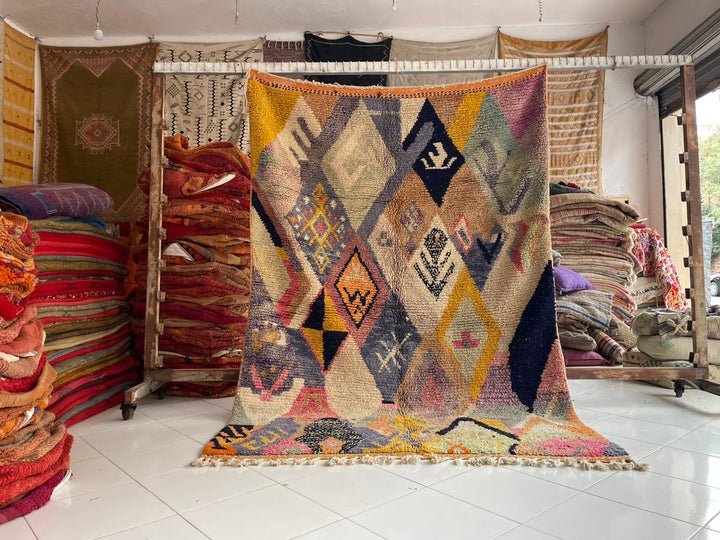Lifestyle shot of a colorful Moroccan rug featuring geometric patterns in a natural setting.
