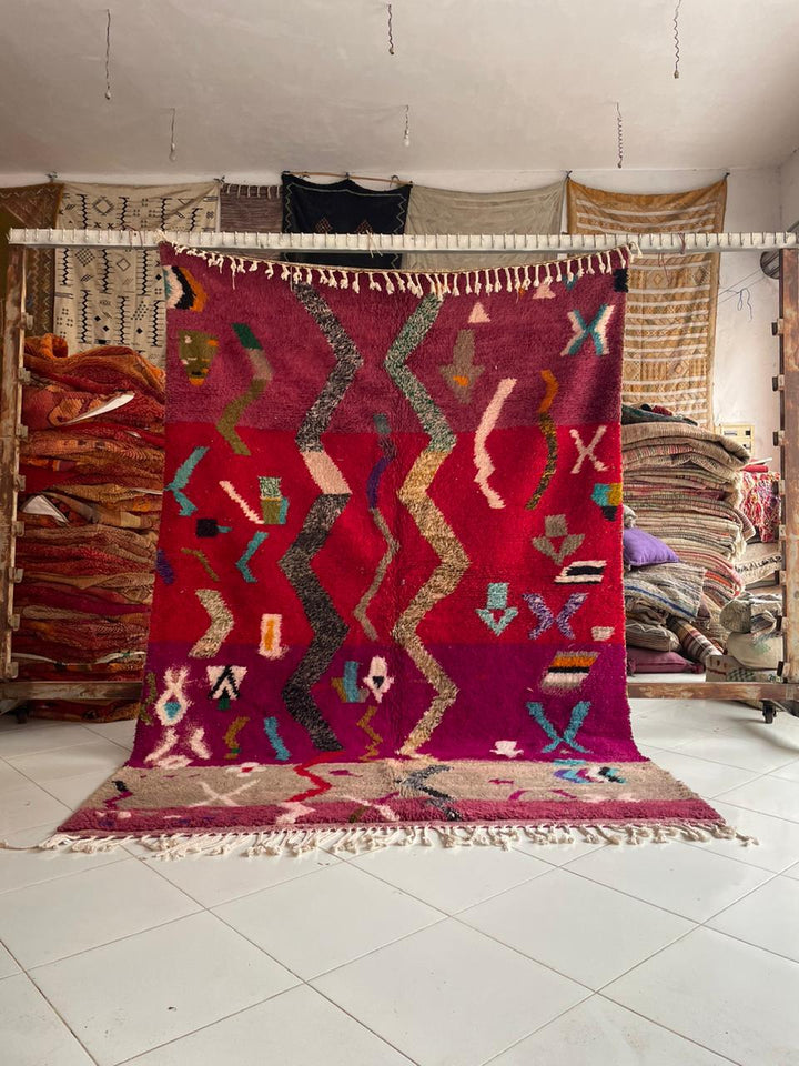 Lifestyle shot of a colorful Moroccan rug with geometric patterns in a natural setting.
