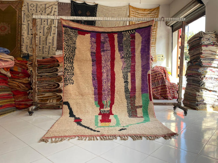 Lifestyle shot of a faded purple Moroccan rug with colorful patterns in a natural setting.