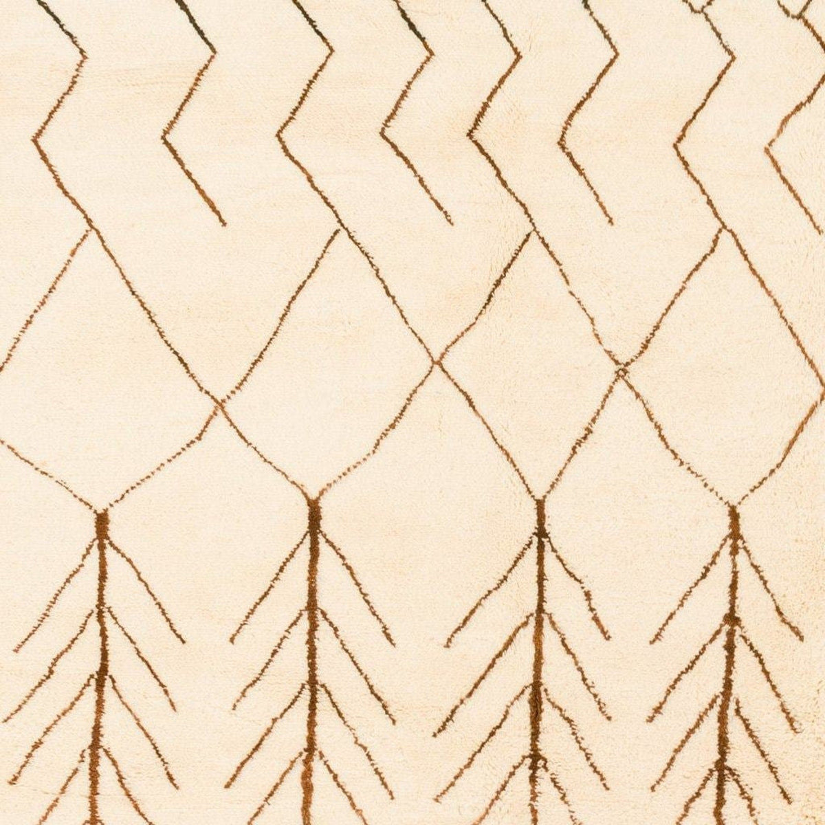 Detail shot of a beige and brown Beni Ourain rug displaying a zigzag design and textured surface.