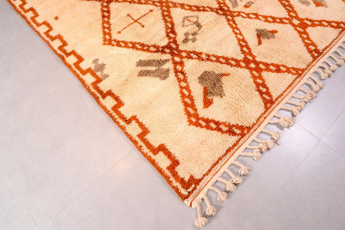 Detailed shot of a beige and brown Beni Ourain rug showcasing its geometric patterns.