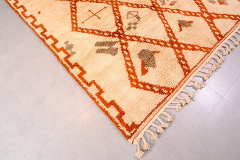 Detailed shot of a beige and brown Beni Ourain rug showcasing its geometric patterns.