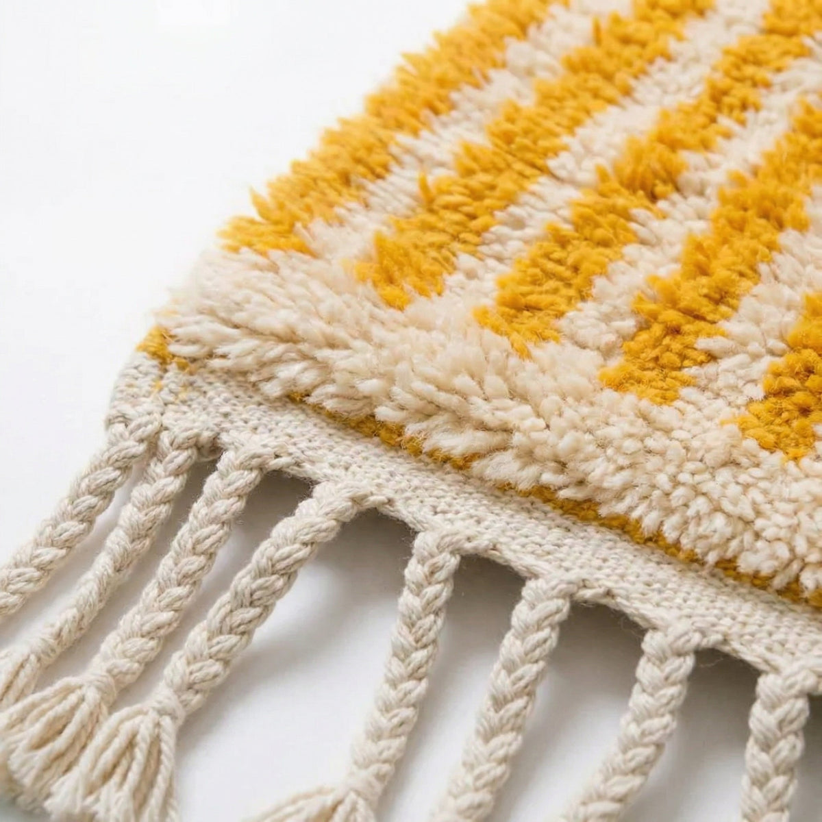 Front view of a mustard striped rug featuring a solid background and fringe edges.