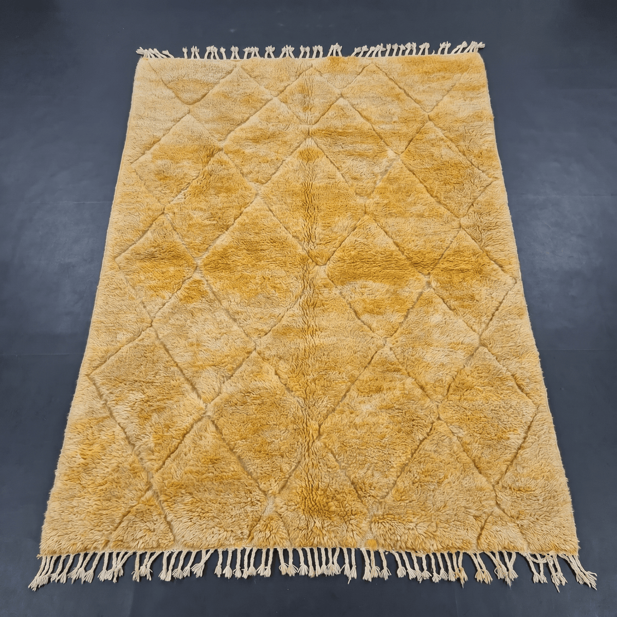 Front view of the mustard yellow Moroccan rug highlighting its design and fringe edges.