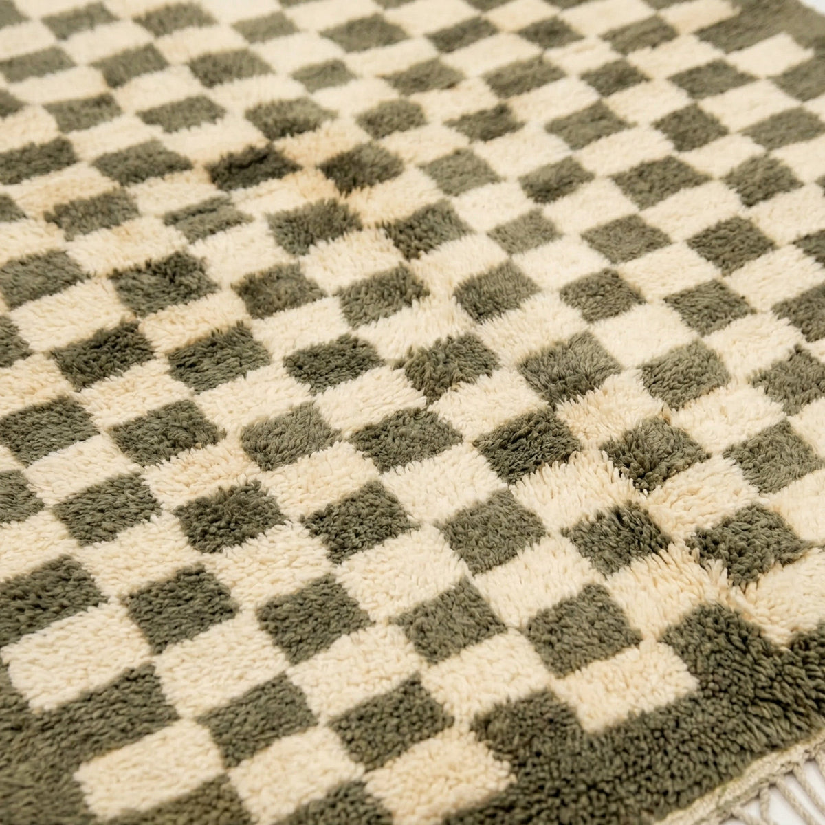 Detail close-up of the olive green checkered rug featuring a textured surface on a white background.