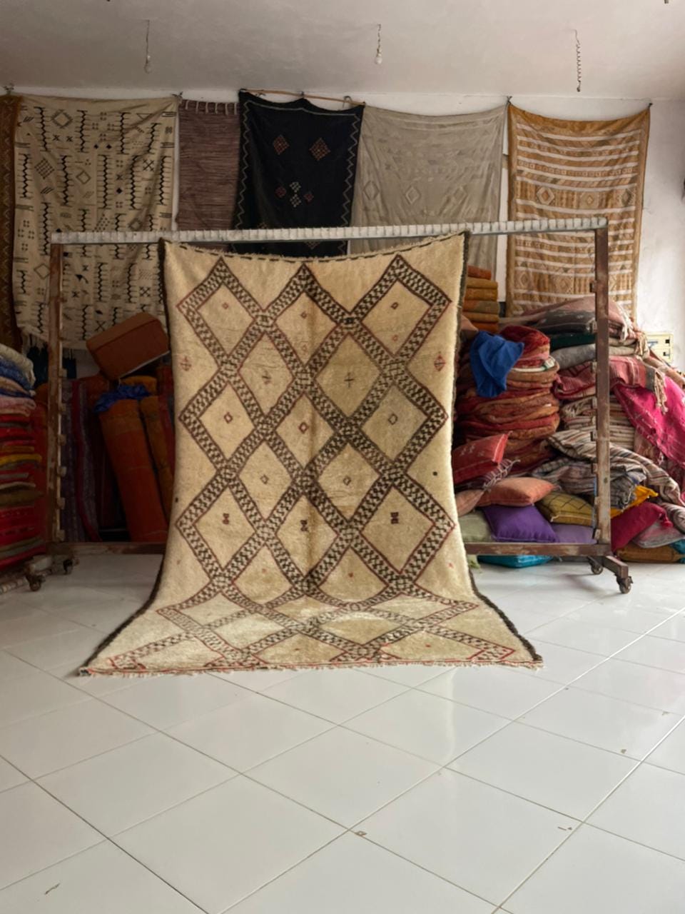 Lifestyle shot of a vintage Moroccan rug featuring geometric patterns in beige and brown.