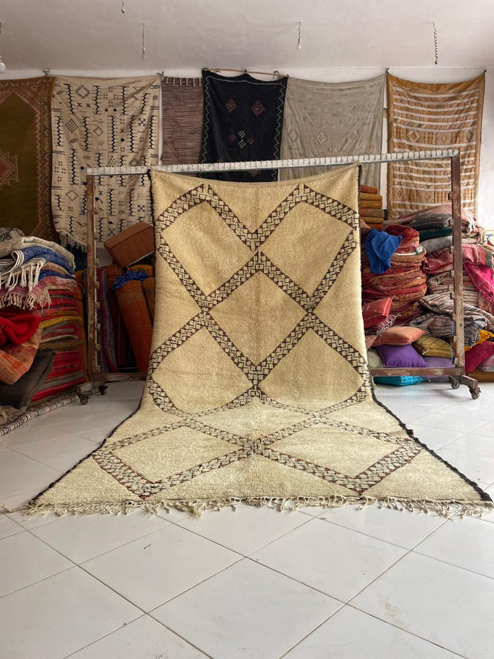 Lifestyle shot of a vintage Moroccan rug with a diamond pattern in beige and black.
